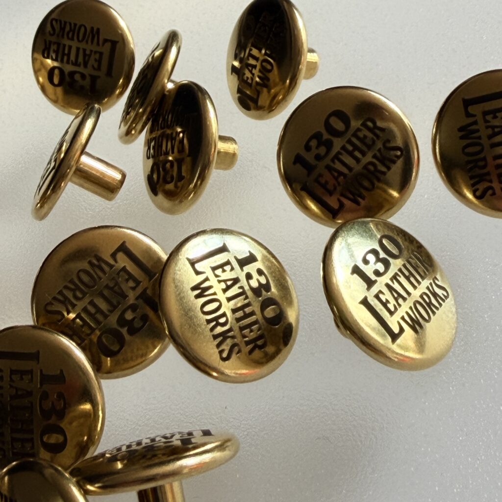 【ご注文品紹介】ジャンパーホックへのロゴ彫刻を承りました